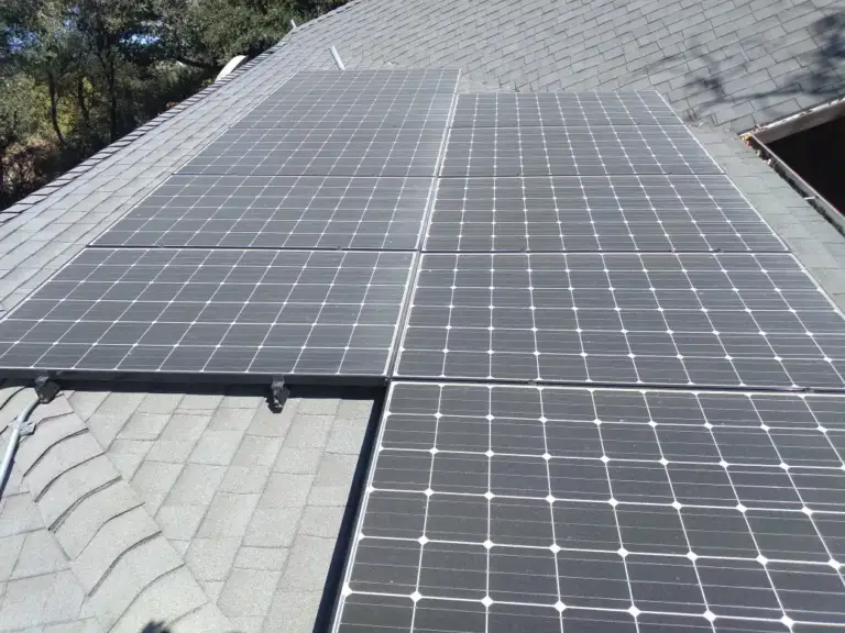 Rows of clean rooftop solar panels on a gray shingle roof