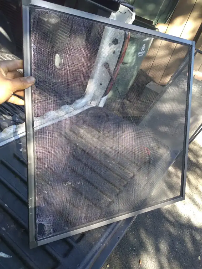 Window screen held up to the light outside